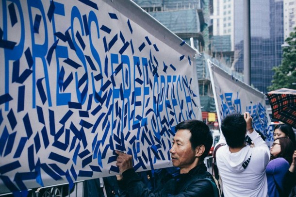 Protestors paste blue ribbons on banners to be presented to Kevin Lau, an editor who was seriously wounded in an attack. Photo: Kevin Yeoh